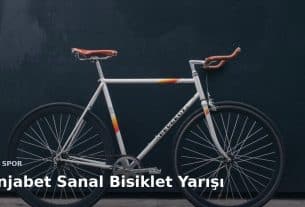 Duvara dayalı yarış bisikleti; üzerinde Benjabet sanal bisiklet yarışı başlığı